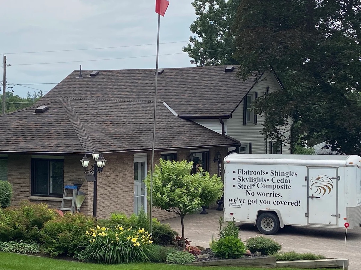 Brick bungalow with a Testarossa Roofing trailer listing flat roofs, shingles, skylights, cedar, and steel services