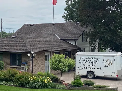 Brick bungalow with a Testarossa Roofing trailer listing flat roofs, shingles, skylights, cedar, and steel services