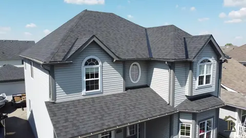 Finished two-storey home with new charcoal architectural shingles, gables and dormer clean and flashed