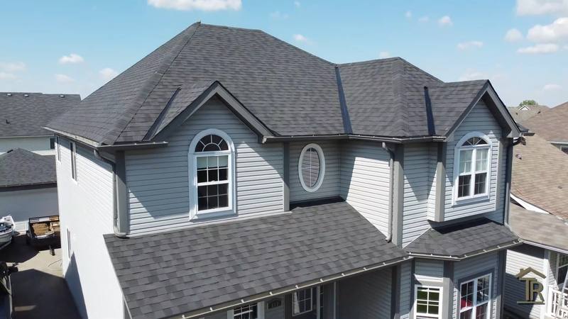 Finished two-storey home with new charcoal architectural shingles, gables and dormer clean and flashed
